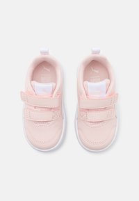 Une paire de baskets pour tout-petits de couleur rose clair avec des semelles blanches et deux bandes auto-agrippantes, vues du dessus sur un fond blanc.