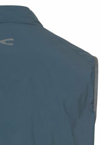 Leichte blaue Weste aus einem glatten, langlebigen Stoff. Verfügt über einen hohen Kragen und dezente reflektierende Akzente entlang der Kanten.