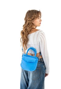 Kék, puffadt táska sima textúrával, két rövid fogantyúval és leválasztható vállpánttal. A logó a fronton látható.