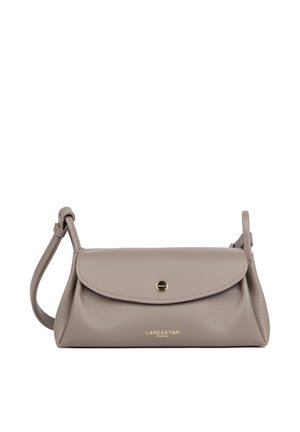 Taupekleurige Lancaster Paris leren schoudertas met gebogen klep, sluiting met goudkleurige knop en verstelbare riem op een witte achtergrond.