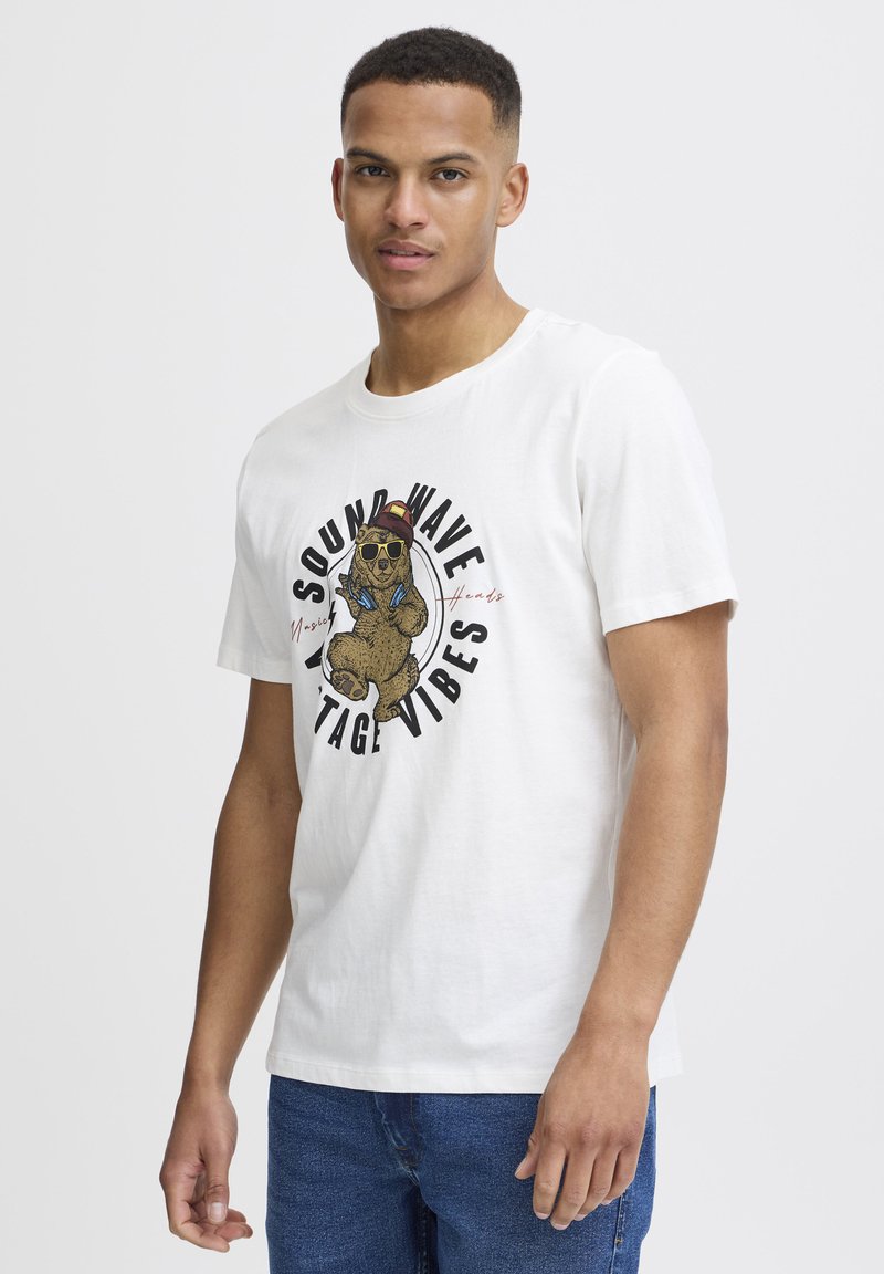 Hvit bomulls t-skjorte med en grafisk illustrasjon av en bjørn som har solbriller, med teksten "SOUND WAVE VINTAGE VIBES" i svart.