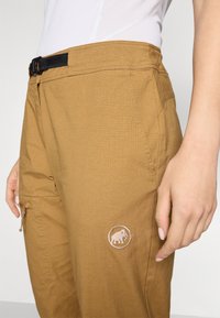 Καφέ παντελόνια πεζοπορίας από ελαφρύ υλικό, με υφή, ρυθμιζόμενη μαύρη ζώνη στη μέση και ένα μικρό κεντητό λογότυπο στο πλάι.