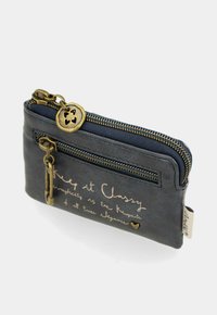 Piccolo astuccio blu navy con zip, dotato di due zip in ottone, ciondolo a forma di cuore e testo in corsivo che recita "Keep it Classy" sul fronte.