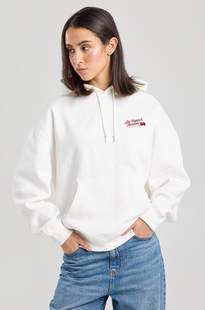 White hoodie with drawstrings and front pocket, featuring red embroidered text that reads "Las Vegas Nevada." Casual fit with ribbed cuffs.