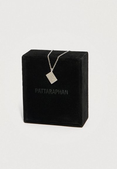 Colar com pendente retangular prateado de superfície texturizada, exibido numa caixa de veludo preto com a marca "PATTARAPHAN".