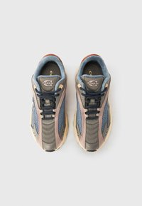 Αθλητικά παπούτσια με μείγμα γκρι διχτυωτού υφάσματος, μπλε λεπτομερειών και μπεζ λαστιχένιες σόλες. Μαύρα κορδόνια και λογότυπο στη γλώσσα ολοκληρώνουν το σχέδιο.