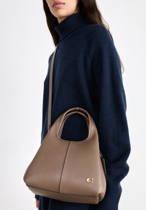 Leather handbag in light brown with a structured shape, a top handle, an adjustable shoulder strap, and a subtle gold logo accent.