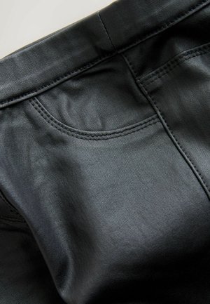 Czarne skórzane spodnie o gładkiej teksturze, z subtelnym połyskiem, z detalami w postaci zaokrąglonych szwów kieszeni oraz klasycznym kroju slim fit.