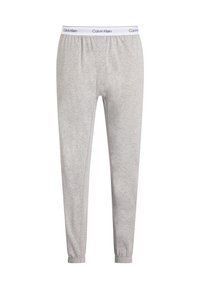 Szürke pamut melegítőnadrág, rugalmas derékkal, rajta fehér "Calvin Klein" logóval. A bokánál nadrágszárak, hogy szűkebb szabású legyen.