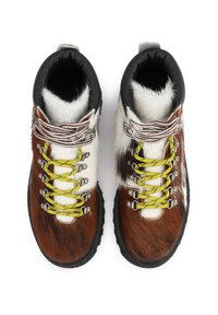 Rudi ir balti kailiniai žygiai batai su juodais guminiais padais, geltonomis ir baltomis raištelėmis bei sidabriniais akcentais.