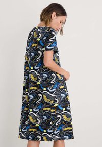 Rochie A-line cu fustă evazată, de culoare neagră, cu un model colorat de lebădă și valuri. Mâneci scurte și decolteu rotund. Material moale și ușor.