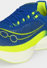 Μπλε και νέον κίτρινο παπούτσι τρεξίματος Saucony Endorphin Elite 2 με πλέγμα στην επιφάνεια, παχιά λευκή σόλα και χαρακτηριστικό σχέδιο κορδονιών.