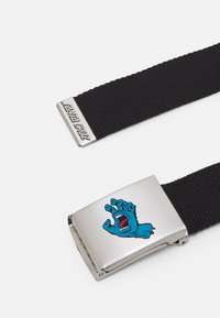 Zwarte gevlochten riem met een zilveren metalen gesp waarop een grafisch motief van een blauwe monsterhand staat en de tekst "Santa Cruz" aan de rand van de gesp.