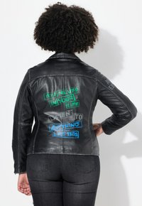Schwarze Lederjacke mit taillierter Passform. Verfügt über farbenfrohe Textgrafiken auf dem Rücken, mit glatter Textur und detaillierter Naht.