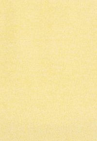 Tessuto a maglia in morbido giallo pastello, con una texture liscia e un motivo fine ed uniforme, senza hardware o accenti visibili.