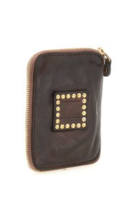 Portafoglio marrone in pelle con zip a giro, borchie dorate che incorniciano una toppa in pelle sul davanti e cursore della zip dorato visibile.