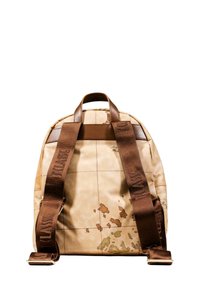 Beżowy plecak z nadrukiem mapy świata, brązowymi skórzanymi akcentami i regulowanymi ciemnobrązowymi paskami z wypukłym napisem.