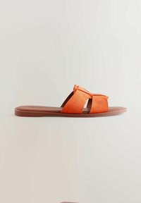 Narancsszínű velúrbőr papucs két keresztpánttal, lapos barna talppal és egyszerű, minimalista kialakítással.