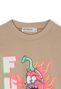T-shirt beige à manches courtes avec un design de piment cartoon coloré, affichant des larmes bleues, entouré d'accents néon roses et verts.