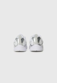 Des chaussures de sport blanches avec une tige en maille texturée et des accents brillants argentés au niveau du talon. Comprend une languette et une semelle rembourrée pour plus de confort.