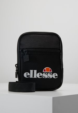 Sort rektangulær skuldertaske med forreste lynlåslomme, hvidt ellesse-logo og justerbar rem på hvid overflade mod en ensfarvet baggrund.