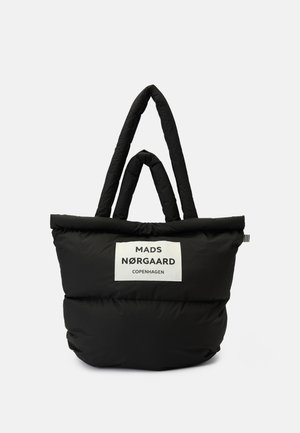 Svart polstret tote bag med doble håndtak og hvit etikett som viser "MADS NØRGAARD COPENHAGEN" på forsiden.