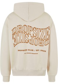 Kremfarget hettegenser med stor, brun grafisk tekst som sier "DROPSIZE CLUB EST. 2020" på baksiden. Har kengurulomme og justerbar hette.