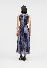 Μάξι φόρεμα από ελαφρύ ύφασμα με μπλε και καφέ αφηρημένο μοτίβο, σχεδιασμένο σε στρώσεις, χωρίς μανίκια, με σφηκοφωλιά στη μέση και φαρδιά φούστα.