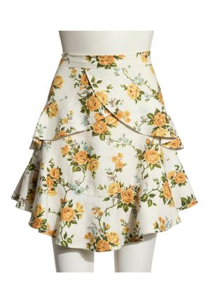 Jupe portefeuille blanche à motifs floraux avec roses jaunes et feuilles vertes, avec des volants superposés et une silhouette évasée.