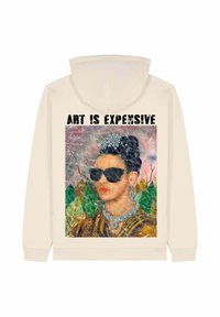 Sweat à capuche couleur crème avec un imprimé graphique d'une femme portant des lunettes de soleil et des bijoux, avec le texte « L’ART EST CHER » au-dessus.