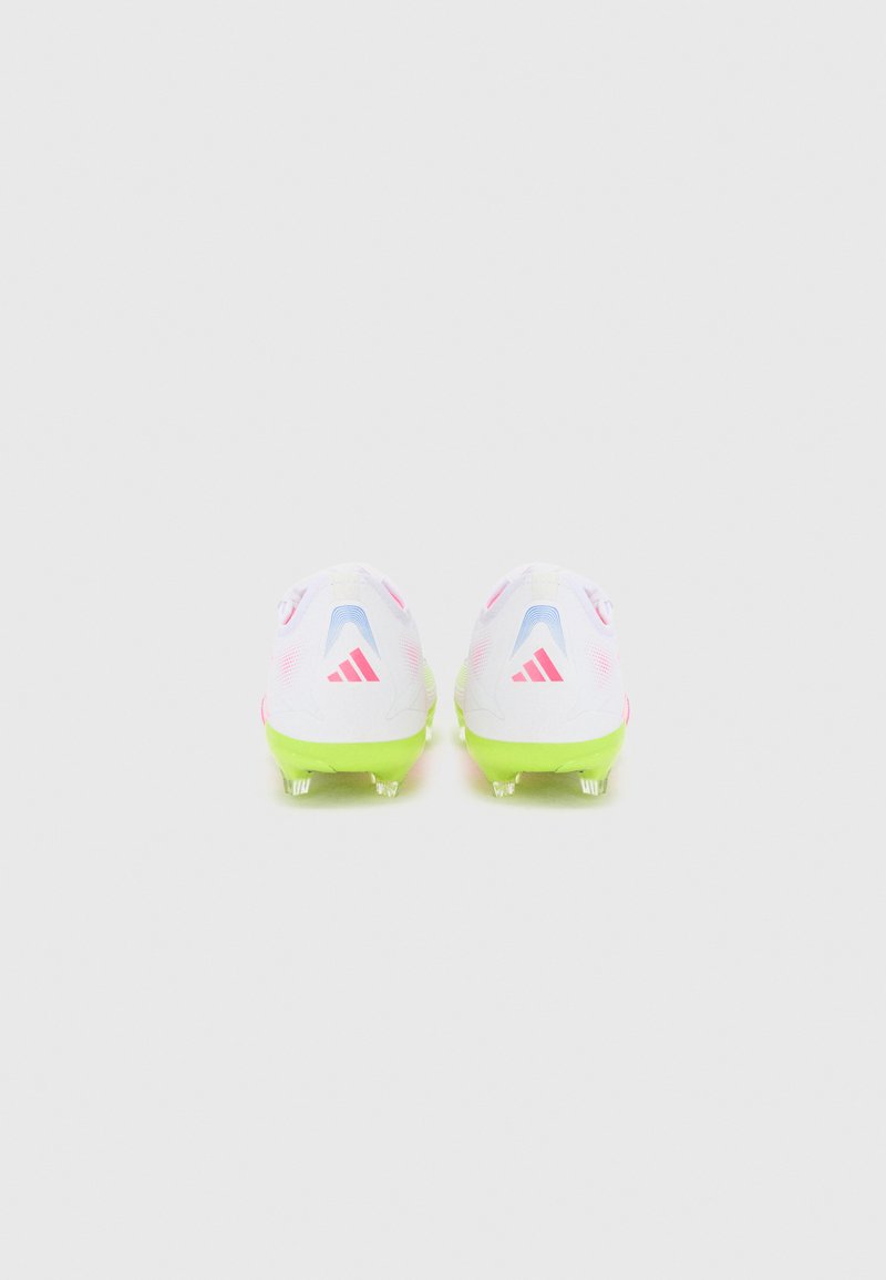 Botas de fútbol con una parte superior blanca, acentos rosas y una suela verde. Presentan un diseño elegante, con una marca visible y tacos translúcidos.
