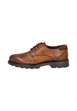 Zapato de vestir marrón de cuero con cordones, suela negra y pequeña etiqueta de marca en el lateral, visto desde el lado exterior.