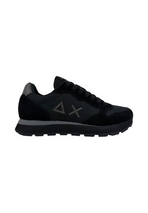 Sneaker nera con lacci neri, suola grigia, tessuto morbido e dettagli in camoscio, con loghi grigi a triangolo e X sul lato.