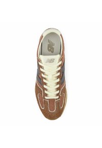 Brown and cream New Balance sneaker with suede and mesh upper, cream laces, and New Balance logo on tongue and insole.