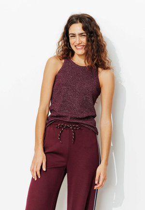 Haut sans manches bordeaux avec un motif en tricot texturé, assorti à un pantalon avec taille élastique et rayures latérales contrastées.