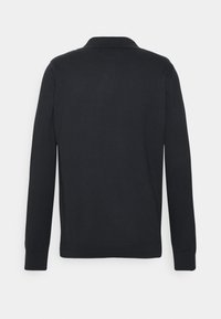 Crni dugosleeve polo majica s rebrastim okovratnikom i manžetama. Glatka tekstura, minimalistički dizajn, bez vidljivih uzoraka ili ukrasa.