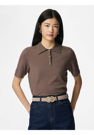 Brun polo i kortærmet med krave, der har knapstolpe og tekstureret stof, kombineret med mørk denimjeans og et beige bælte.