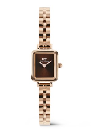 Rozā zelta sieviešu rokas pulkstenis ar taisnstūra brūnu ciparnīcu, analogiem rādītājiem un saistītu metāla siksnu no Daniel Wellington.