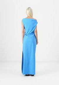 Μπλε, φόρεμα μέχρι το γόνατο με ασύμμετρη τιράντα, χαλαρή εφαρμογή και λεπτομέρεια στροφής στην πλάτη; λεία υφή, μινιμαλιστικός σχεδιασμός, πλαϊνό σχισίμα.