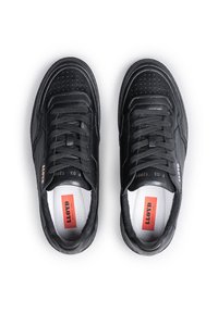 Sneakers in pelle nera con design perforato, punta rotonda, lacci piatti e soletta ammortizzata. Presentano il logo e un'etichetta rossa all'interno.