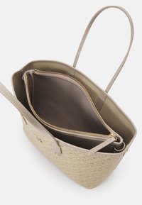 Borsa tote beige con un esterno intrecciato a motivo, due lunghe tracolle e una tasca interna con zip. Foderata con un materiale marrone liscio.