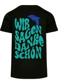 Sort t-shirt med fed, turkise tekst, der står "WIR SAGEN DANKE SCHÖN", ledsaget af et blåt delfin grafik.