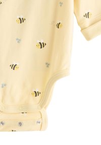 Body bébé en coton jaune à manches courtes, avec un motif d'abeilles. Fermeture à pression en bas et texture douce et lisse.