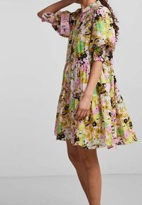 Bloemenjurk met puffmouwen, met roze, groen, gele en zwarte patronen. Losvallend, knie-lengte met een geplooide rokontwerp.