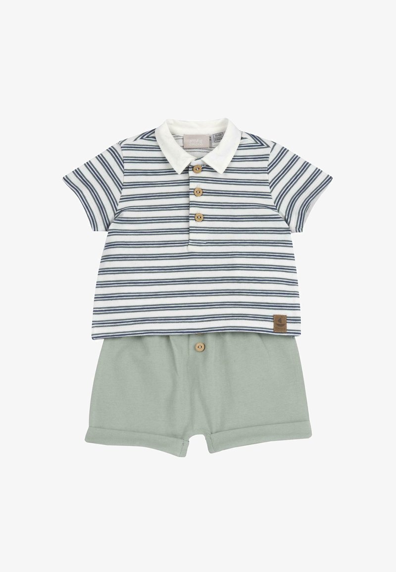 Polo shirt à manches courtes rayé en blanc et bleu marine, doté de boutons en bois. Associé à un short vert clair, également avec des accents de boutons en bois.