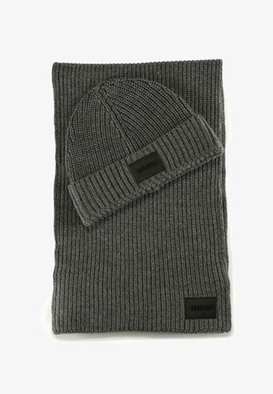 Dark gray ribbed knit scarf and matching beanie hat, both featuring black rectangular Hugo brand patches.