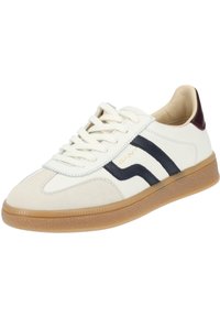 White sneaker with navy stripes, beige suede toe, and gum sole. Features lace-up design and gold branding. Soft interior lining.