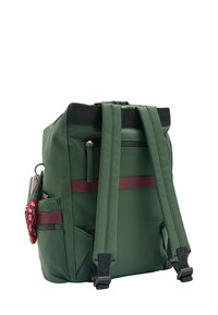 Zielony plecak wykonany z trwałego materiału, z regulowanymi ramiączkami, zapinaną na zamek tylną kieszenią oraz bocznymi kieszeniami z czerwonym akcentem.