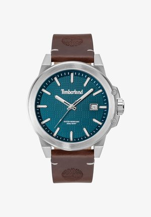 Okrągły zegarek ze stali nierdzewnej z turkusową tarczą oraz wytłoczonym wzorem. Brązowy skórzany pasek z logo kontrastuje z metalową obudową.