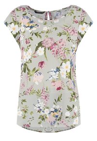 Blouse fleurie en tissu vert clair avec manches courtes, présentant des motifs floraux roses, blancs et bleus, et un détail d'encolure en forme de trou de serrure.